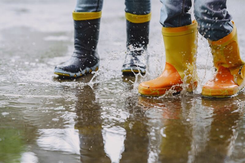 Enfant qui joue dans les flaques pendant inondation