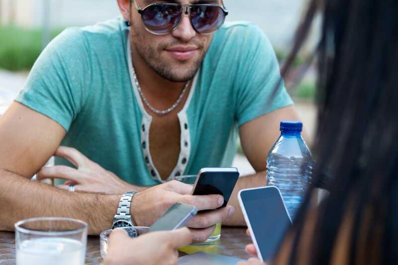 Un homme envoie un MMS depuis son smartphone