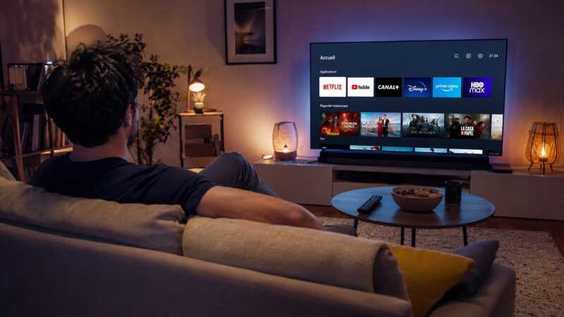 homme en noir devant sa TV