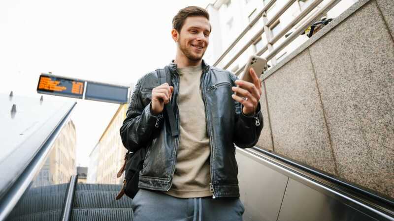Un homme regarde son téléphone dans un escalator