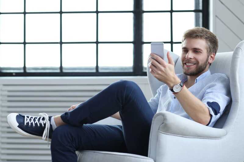 Homme content devant son smartphone