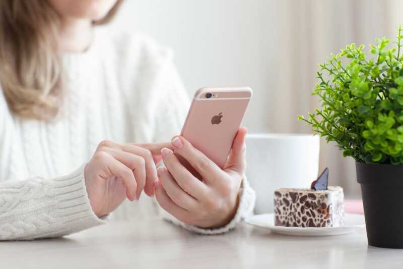 Une femme qui tient un iPhone en main