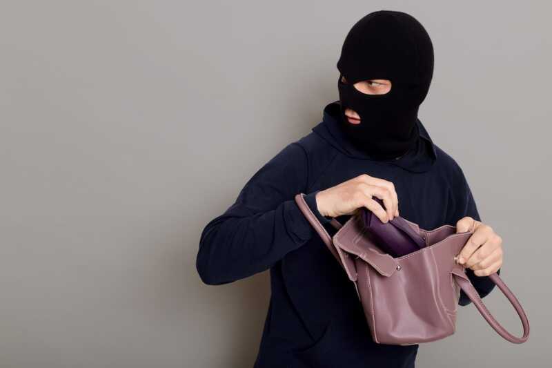 cambrioleur vole des objets dans un sac