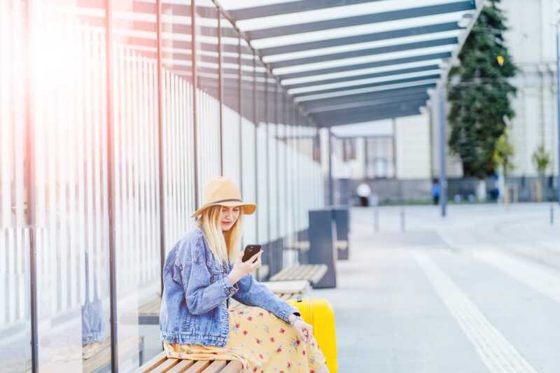 Une jeune femme consulte Internet sur son téléphone en ville