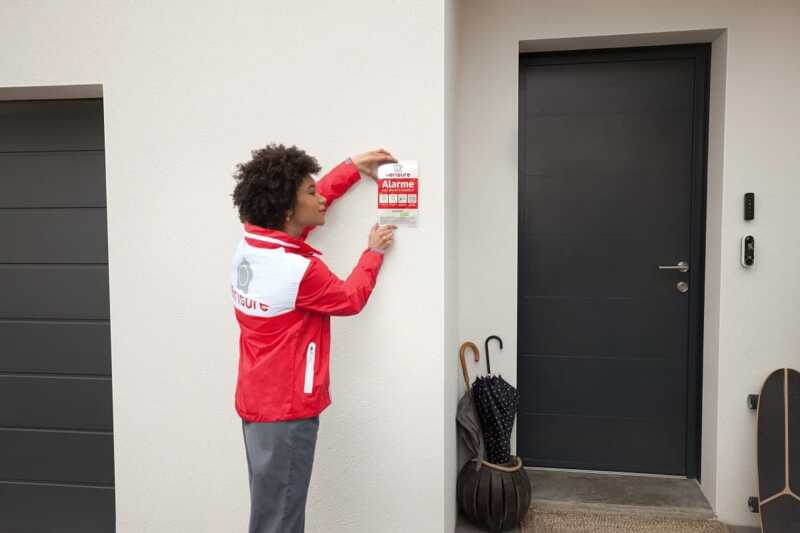technicien pose une plaque dissuasive