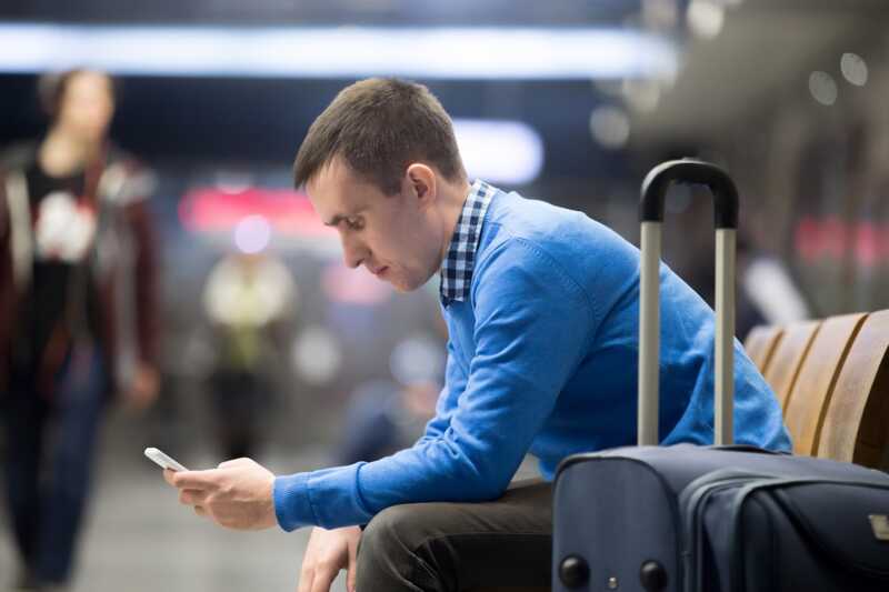 Homme utilisant son smartphone dans un aéroport